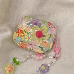 Detail view of floral AirPods case featuring 3D yellow flower and a beaded charm strap.
