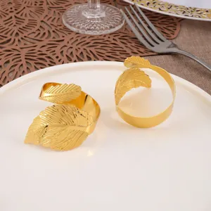 Primer plano detallado de dos elegantes servilleteros de metal dorado con forma de hoja