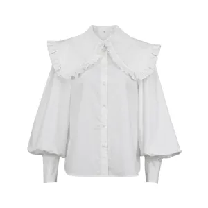 Close-up detail of white cotton blouse featuring ruffled doll collar and elegant puff sleeves