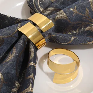 Primer plano de un elegante servilletero de metal dorado sobre una servilleta de tela