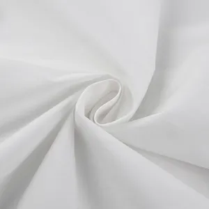 Detail view of premium soft white 100% cotton fabric showing smooth texture and folds