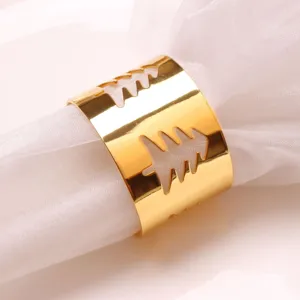 Detalle de servilletero de metal dorado con recorte de árbol de Navidad elegante