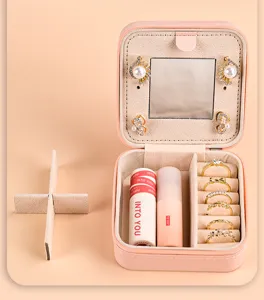 Detailed view of pink jewelry box interior with mirror, ring slots, and divider