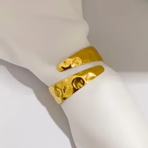 Primer plano de servilletero de metal martillado irregular dorado para mesa
