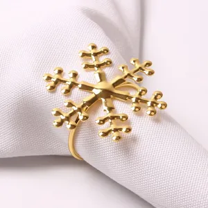 Vista detallada de un elegante servilletero de metal dorado con diseño de copo de nieve
