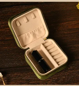 Detailed macro view of green velvet jewelry box interior compartments with lipstick