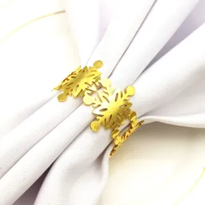 Primer plano de un elegante servilletero dorado metálico con forma de copo de nieve