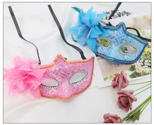 Vista di dettaglio di maschere di carnevale con paillettes, fiore laterale e nastri.