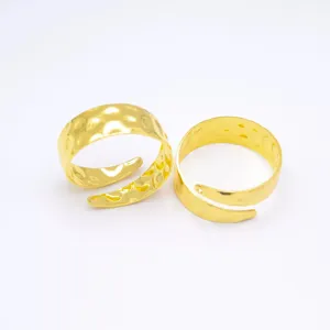 Primer plano de servilleteros de metal dorado con textura martillata para la mesa