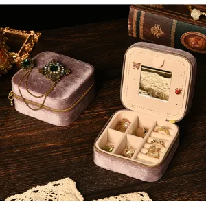 Macro view of purple velvet jewelry storage box featuring built-in mirror and ring slots