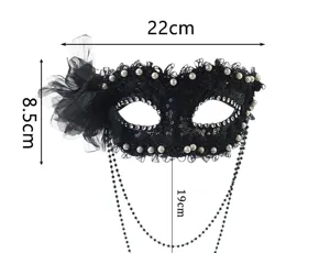 Black lace masquerade mask detail view featuring pearls, rhinestones, and hanging beads.