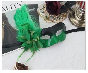 Detailed view of masquerade mask featuring vibrant green feathers and floral side decor.