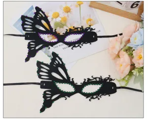 Close-up detail of black butterfly masquerade masks adorned with purple and green rhinestones.