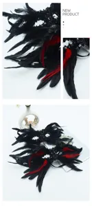 Dettaglio maschera gotica in piume nere e rosse con paillettes e decoro per feste da ballo.