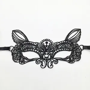 Nahaufnahme der feinen Details der schwarzen Spitzenmaske mit filigranem Muster und Bändern.