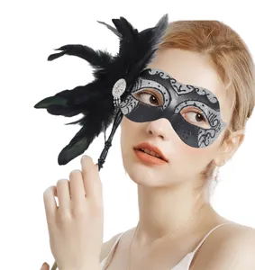 Dettagli in primo piano della elegante maschera in piuma con strass scintillanti e manico.