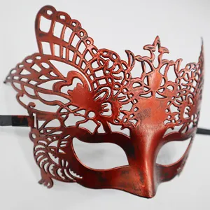 Gros plan détaillé du masque demi-visage de mascarade rouge vintage avec des motifs creux complexes.