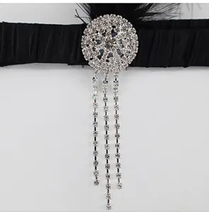 Close-up detail of 1920s vintage black feather rhinestone headband with crystal fringe tassels.