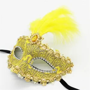 Exquisita máscara de mascarada amarilla con encaje, pedrería, pluma y gema para fiestas.