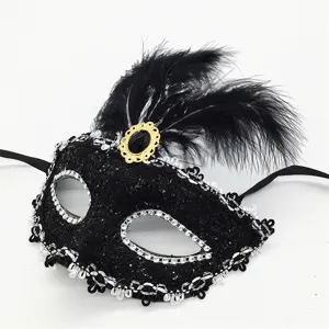 Máscara de mascarada negra con plumas, pedrería y gema dorada para fiestas de disfraces.