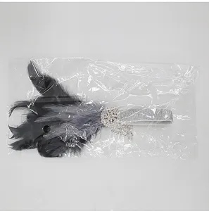 Detailed view of 1920s flapper feather headband, black feathers with rhinestone tassel.