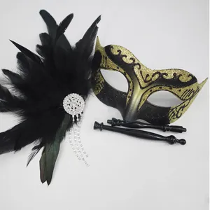 Dettaglio in primo piano della maschera in piuma di carnevale con strass e manici.