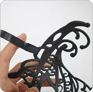 Dettaglio della maschera di carnevale con intricato motivo nero e tono verde vintage.