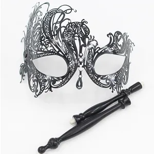 Gedetailleerde close-up van het zwarte opengewerkte masker met schitterende strass-steentjes.