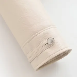 Vue détaillée de la manche de veste en similicuir beige pour femme avec bouton.