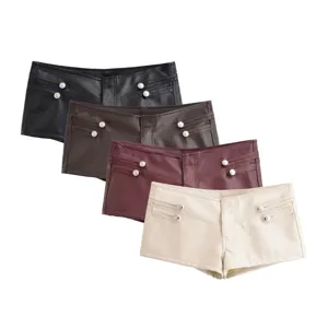 Gros plan sur les détails du short en similicuir avec boutons décoratifs et design chic.