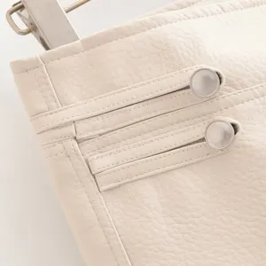 Détail taille short en similicuir blanc avec boutons métalliques mode vue rapprochée