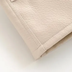 Vue détaillée de la texture du tissu de la veste en similicuir et de la couture.