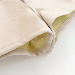 Gros plan détaillé de la texture en cuir synthétique avec des coutures et une doublure.