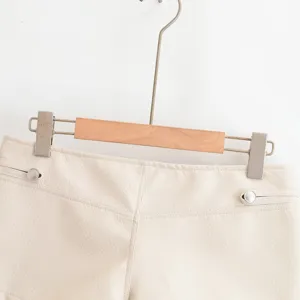 Détail de short en similicuir, avec boutons-pression métalliques et ceinture.