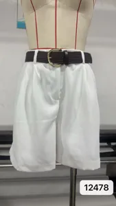 Vista detallada de pantalones cortos blancos de talle alto plisados con cinturón trenzado.