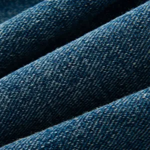 Close-up blue denim fabric texture detail of casual women jacket, showing fine woven pattern.