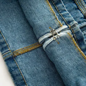 Close-up detail of women denim jacket showing contrast stitching and metal hook fastener.
