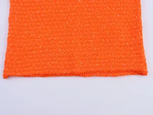 Detailaufnahme von orangefarbenem Pailletten-Metallic-Strickstoff fur modische Damen Tops.