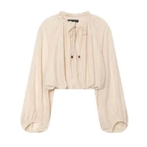 Close up detail view of women solid color beige ruffle collar long lantern sleeve blouse top in summer