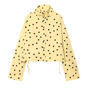 Yellow polka dot high collar long sleeve jacket detail view, front button closure and drawstring hem.