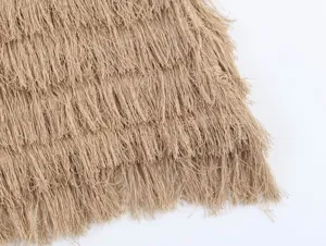 Beige fringe knit top detail close-up, stylish women's clothing texture presentation showcase.
