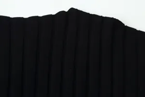 Nahaufnahme von schwarzem Strickstoff mit feiner vertikaler Plissee-Struktur und Qualität.