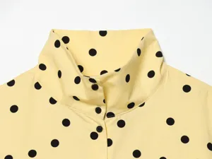 Yellow and black polka dot high collar blouse detail, stylish retro summer fashion.