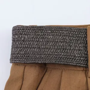 Primer plano detallado de pantalones cortos de mujer de talle alto con cinturón trenzado.