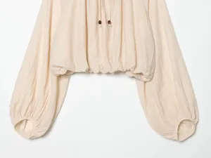 Beige long lantern sleeve blouse detail with drawstring and wooden bead decoration