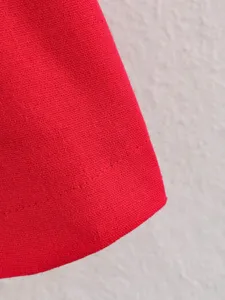 Red trench coat fabric and stitching detail, showing fine texture and sewing craftsmanship.