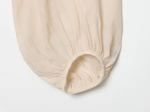 Close-up detail of women lantern sleeve with soft crinkled texture in a neutral beige.