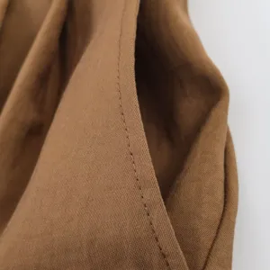 Detalle de bolsillo de pantalones cortos de talle alto marrones, estilo casual minimalista.