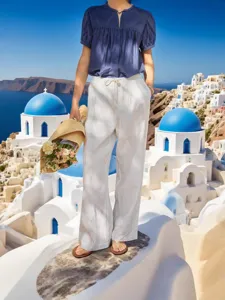 Detail view of white cotton drawstring casual trousers featuring a straight wide-leg fit.
