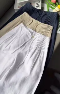 Detail view of casual drawstring wide-leg trousers in multiple colors, featuring front pleats.